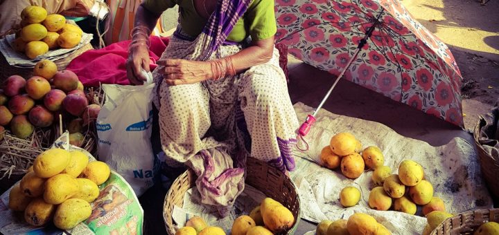 woman in dress sitting near fruits